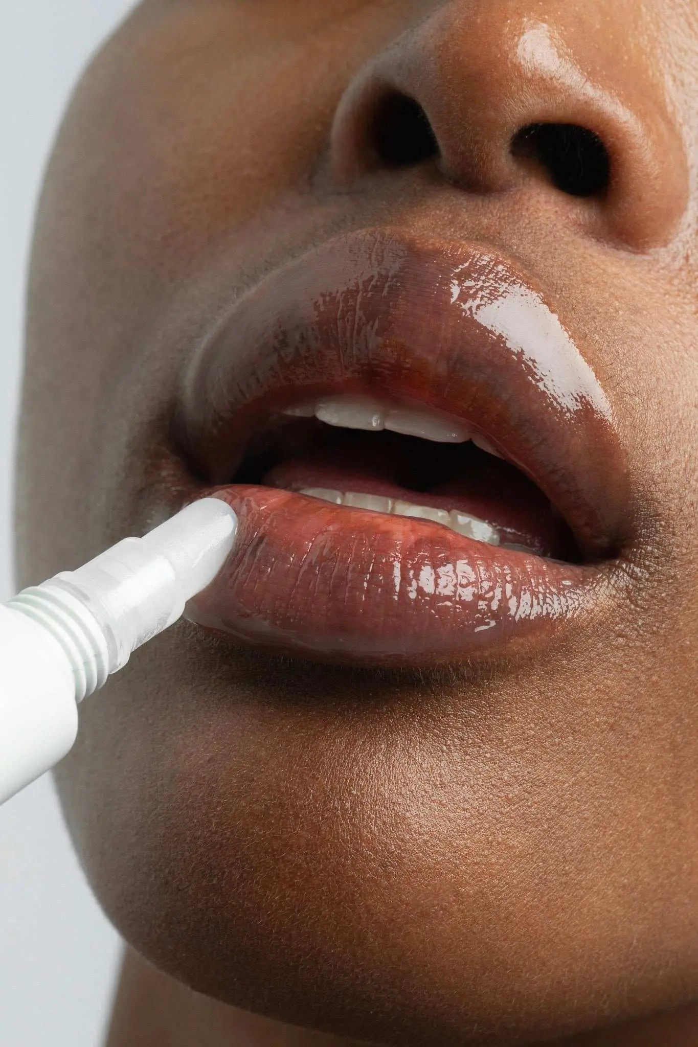 Peptide Lip Treatment being applied for glossy, hydrated lips.